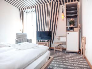 a living room with two beds and a television at Hotel Bleibtreu Berlin by Golden Tulip in Berlin