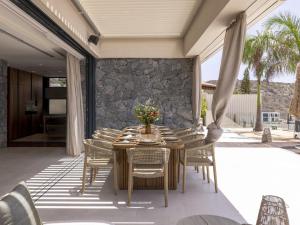 a dining room with a table and chairs on a patio at Villa Kailani in Adeje +32 photos