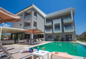 an apartment with a swimming pool and a building at Patiras Deluxe B&B in Limenaria