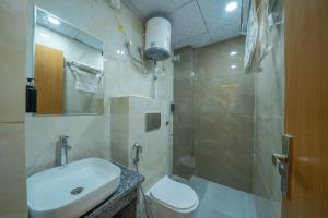 a bathroom with a sink and a toilet and a shower at Krishna Abode by Perfect Stayz near Prem Mandir with Parking in Vrindāvan +53 photos
