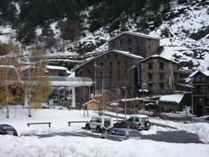 eine Gruppe von Autos, die auf einem Parkplatz im Schnee geparkt sind in der Unterkunft Hotel Montané in Arinsal