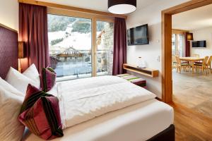 Habitación de hotel con cama y ventana grande en Gletscherblick B&B, en Ischgl