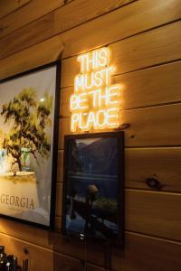 a sign that says this must be the place next to a tv at Luxe Lodge Escape - Hot Tub-Outdoor Movies-Game Room-Fire Pit in Dahlonega