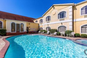 a swimming pool in front of a building at Quality Suites North Houston - Spring in Houston