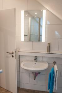 ein Bad mit einem Waschbecken und einem Spiegel in der Unterkunft Aaltine 2 in Bad Bentheim