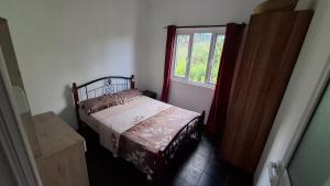 ein kleines Schlafzimmer mit einem Bett und einem Fenster in der Unterkunft Résidence La Montagne in Saint Gabriel