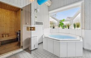 a bathroom with a tub and a window at Strandblick 30 in Schönhagen +21 photos