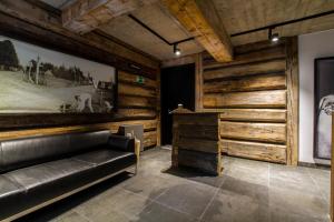 a leather couch in a room with wooden walls at Apartament Ornak in Zakopane