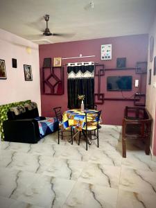 a living room with a table and a couch at Ocean Pearl Beach Villa & Retreat in Mahabalipuram