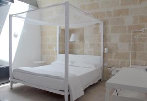a bedroom with a white bed with a canopy at Lamia Room Rentals in Matera