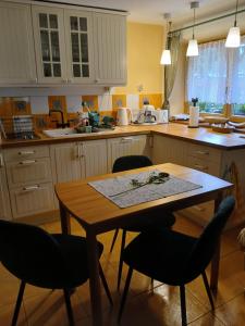 a kitchen with a wooden table and chairs at Skalny ogród in Poronin