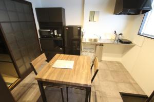 Una pequeña cocina con una mesa y un refrigerador. en 抹茶庵伏見京都 Matcha-An Fushimi Kyoto, en Kioto