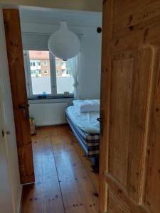 una puerta abierta a un dormitorio con cama y ventana en Mysigt stenhus i Simrishamn, en Simrishamn