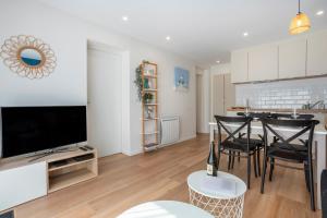 a kitchen and living room with a table and chairs at L’Escale – Tout à pied à Ste-Marine in Combrit