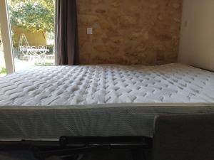 a bed in a room next to a window at Chez Anaïs in Cénac-et-Saint-Julien