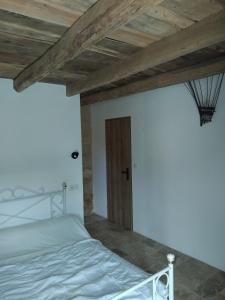 a bedroom with a white bed and a wooden ceiling at Chez Anaïs in Cénac-et-Saint-Julien