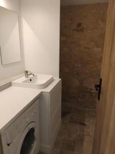 a bathroom with a washing machine and a sink at Chez Anaïs in Cénac-et-Saint-Julien