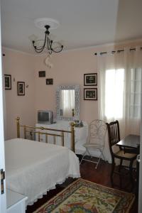 a bedroom with a bed and a desk and a mirror at C&C Home in Ponta Delgada