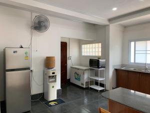 a kitchen with a white refrigerator and a microwave at Cozy house in Vientiane in Vientiane