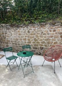two chairs and a green table and a chair at La Maison du pont in La Roche-sur-Yon
