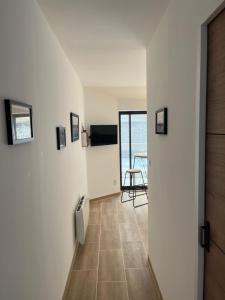 a hallway with a door leading to a room with a table at La Maison du pont in La Roche-sur-Yon