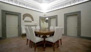 a dining room with a wooden table and white chairs at Hotel Renaissance in Florence