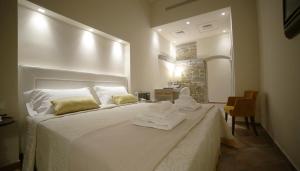 a bedroom with a white bed with towels on it at Hotel Renaissance in Florence +43 photos