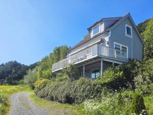 a house on a hill next to a dirt road at 8 person holiday home in Sørbøvåg in Sørbø