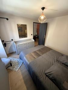 ein Schlafzimmer mit zwei Betten, einer Kommode und einem Spiegel in der Unterkunft Le RC in Bagnols-les-Bains