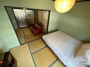 Un dormitorio con una cama y una silla roja. en 抹茶庵伏見京都 Matcha-An Fushimi Kyoto, en Kioto 59 fotos más