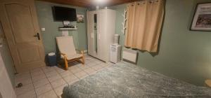 een slaapkamer met een bed en een stoel erin bij Studio Tranquillo avec piscine et salle de sport in Istres