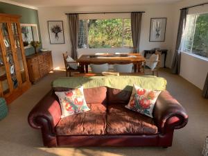 un salon avec un canapé en cuir et une table dans l'établissement Fish Eagle Cottage, 