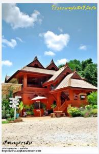 a large building with an umbrella in front of it at Oopkaew Resort in Pua