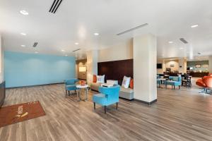 a waiting room with blue chairs and a couch at Sleep Inn Lancaster Dallas South in Lancaster