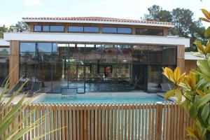 a house with a pool in front of it at Domaine du Ferret Restaurant & Spa in Cap-Ferret