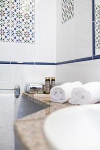 uma casa de banho com toalhas num balcão e um lavatório em Le Lido em Propriano