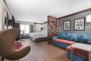 a hotel room with a couch and a bed at The Leo Collection Detroit, an Ascend Collection Hotel in Lincoln Park +98 photos