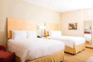 two beds in a hotel room with white sheets at Radisson Hotel Yuma in Yuma +25 photos