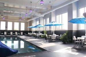 a pool with tables and umbrellas in a building at Radisson Blu Mall of America in Bloomington