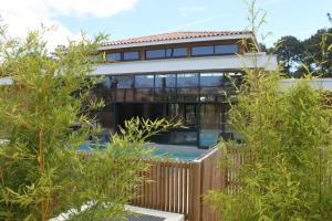a house with a swimming pool and trees at Domaine du Ferret Restaurant & Spa in Cap-Ferret
