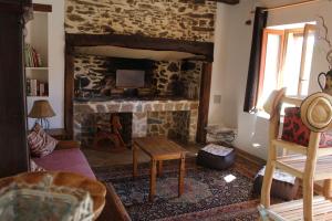 a living room with a stone fireplace with a tv at Ter'lenn in Beyssac