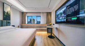 - une chambre avec un grand lit et un grand écran dans l'établissement GreenTree Inn Beijing Changping District North China Electric Power University Business Hotel, à Yongfengtun
