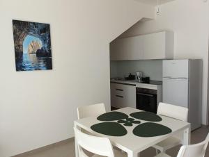 a kitchen with a table with chairs and a refrigerator at Dara Holiday Apartments in Marsala