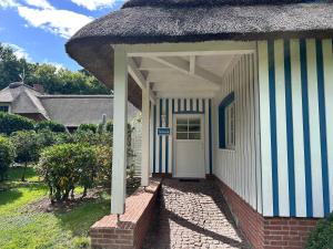a white and blue building with a white door at Cozy Wohnung fuer 4 Gaeste mit Terrasse unter Reet in Sankt Peter-Ording
