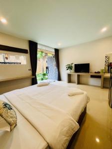 a large bedroom with a large bed with a window at The Strand Resort Samui in Ban Ko Khwan