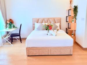 a bedroom with a bed with a vase of flowers on it at Luxury Lucentia Residence Bukit Bintang KLCC By IZ in Kuala Lumpur +52 photos