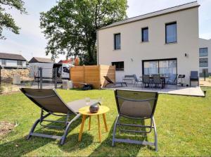 a group of chairs and a table in front of a house at Ker Phan Cozy urban cottage with hot tub in Saint-Aubin-du-Cormier