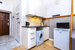 a kitchen with a washing machine and a washer at Rently Apartments in Old Town in Kraków