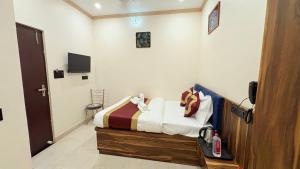 a bedroom with a bed and a tv in a room at TirthAura The Kashi Elegance 2 Mins Walk to Kal Bhairav Temple in Varanasi