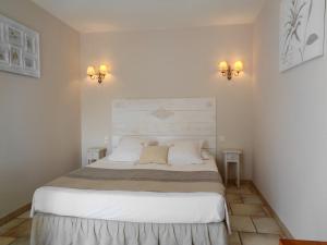 a bedroom with a large white bed with two lights at Clos des Lavandes - Chambres et Suites de charme climatisées-Luberon in Lacoste